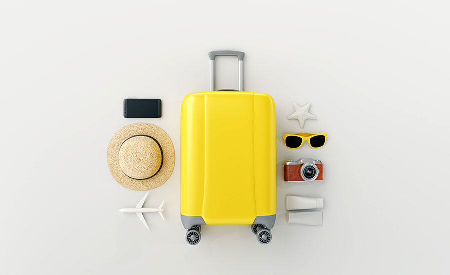 A yellow suitcase with travel essentials surrounding it